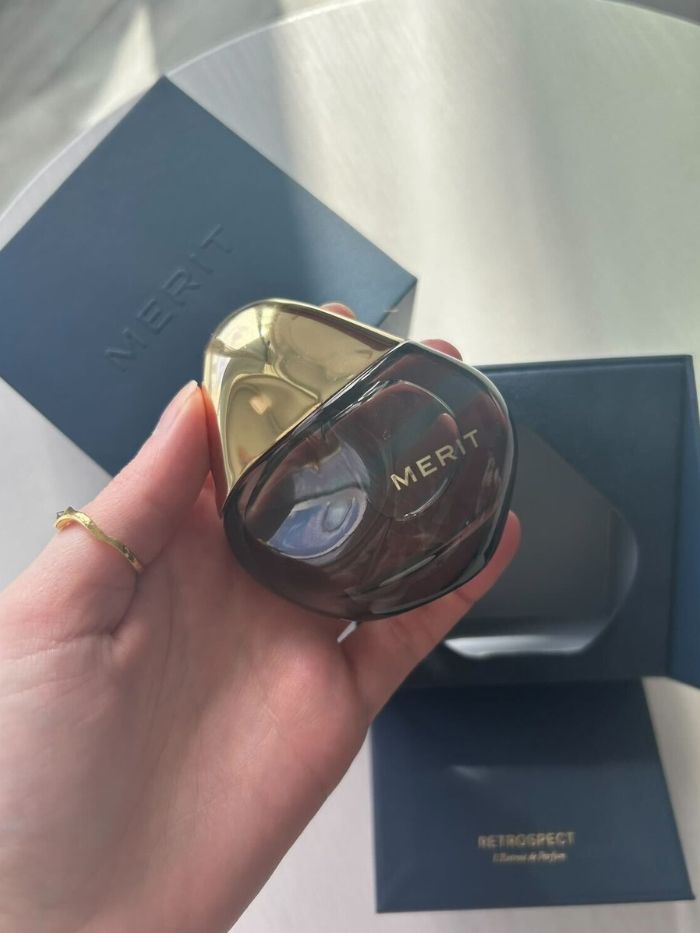 Junior beauty editor Grace Lindsay holding the Merit Retrospect perfume