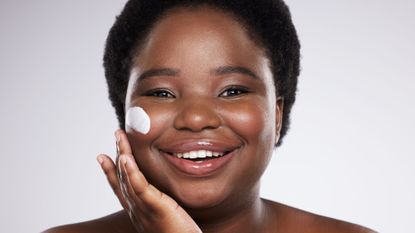 best moisturiser for dry skin - woman with face cream on her cheek smiling - getty images 1680079842