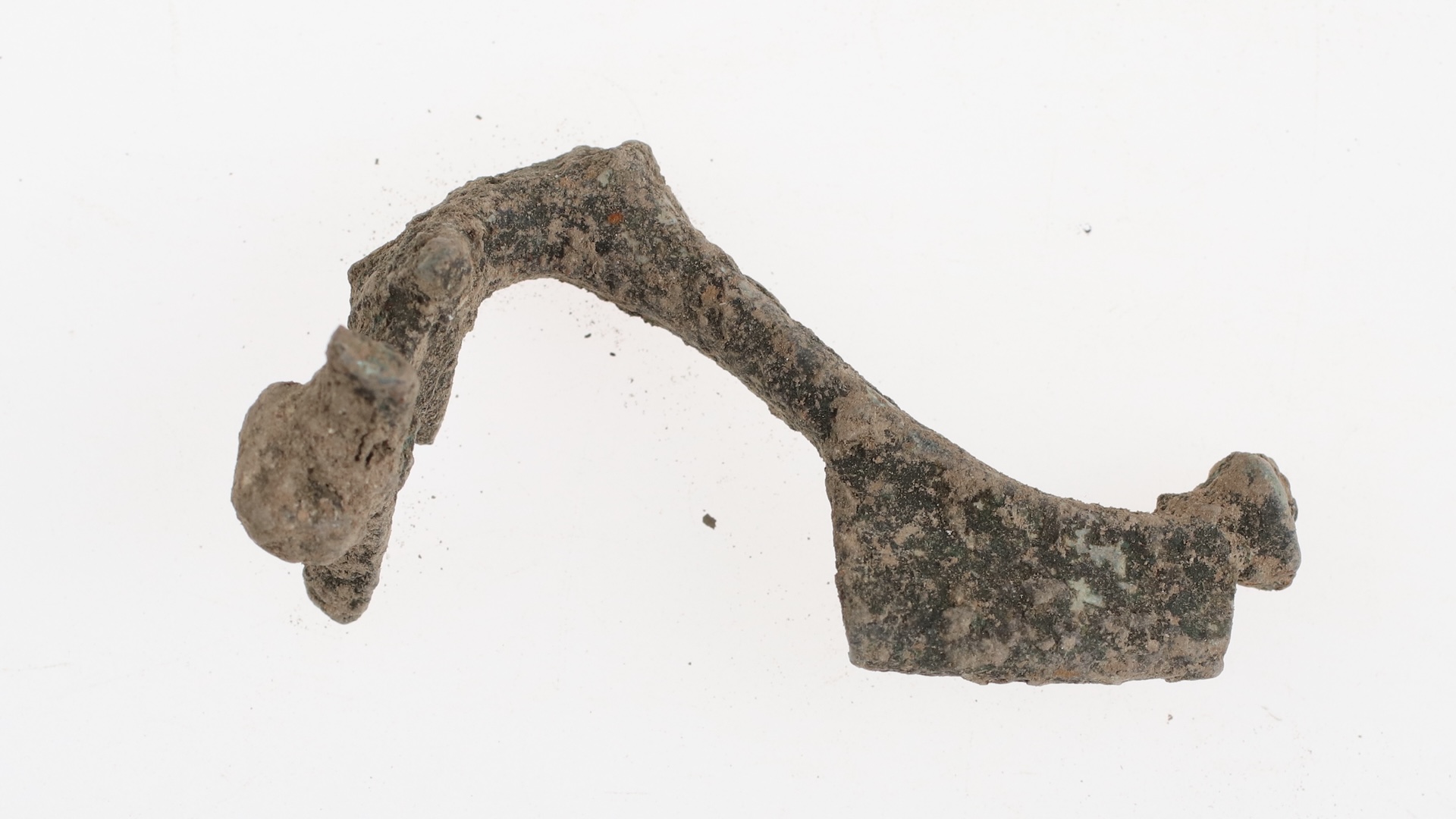 a weathered metal brooch