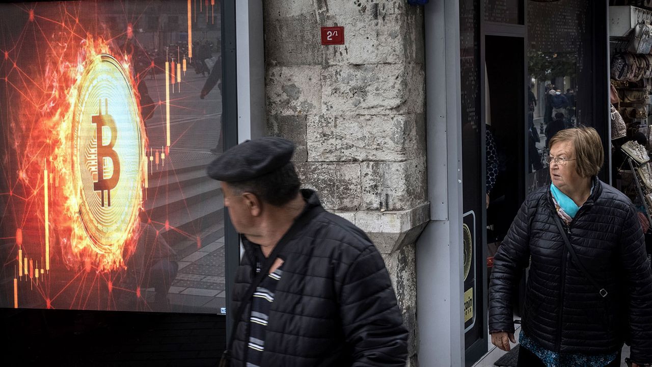 People looking at a bitcoin sign