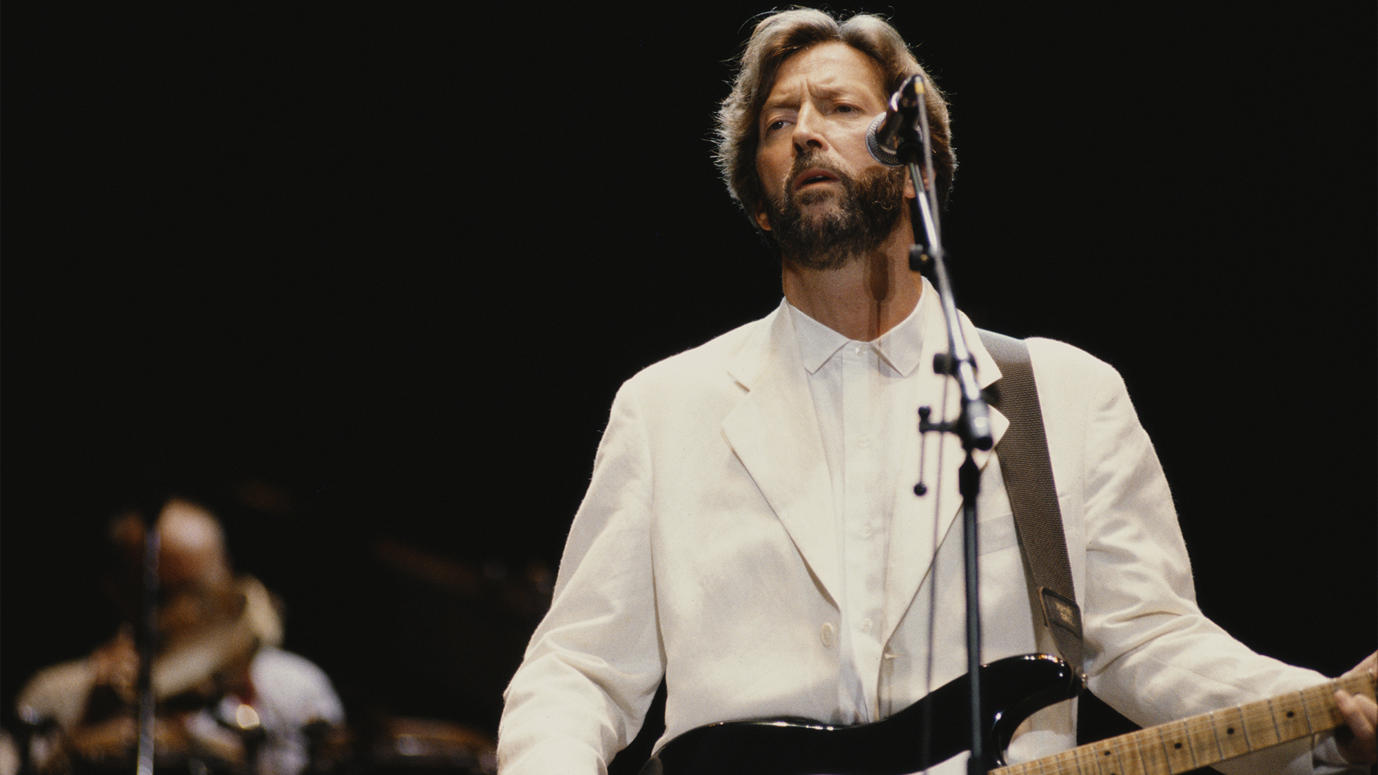 English guitarist Eric Clapton performs live on stage playing a black Fender Stratocaster guitar at Wembley Stadium in London in June 1992. 