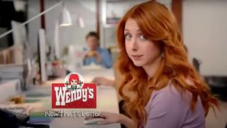 Morgan Smith sits at a conference table looking at the camera for Wendy's,
