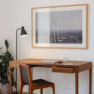 Plain wooden desk with framed photo above