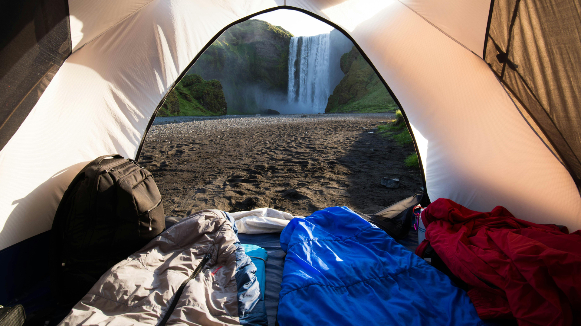 sleeping bags in tent with waterfall view