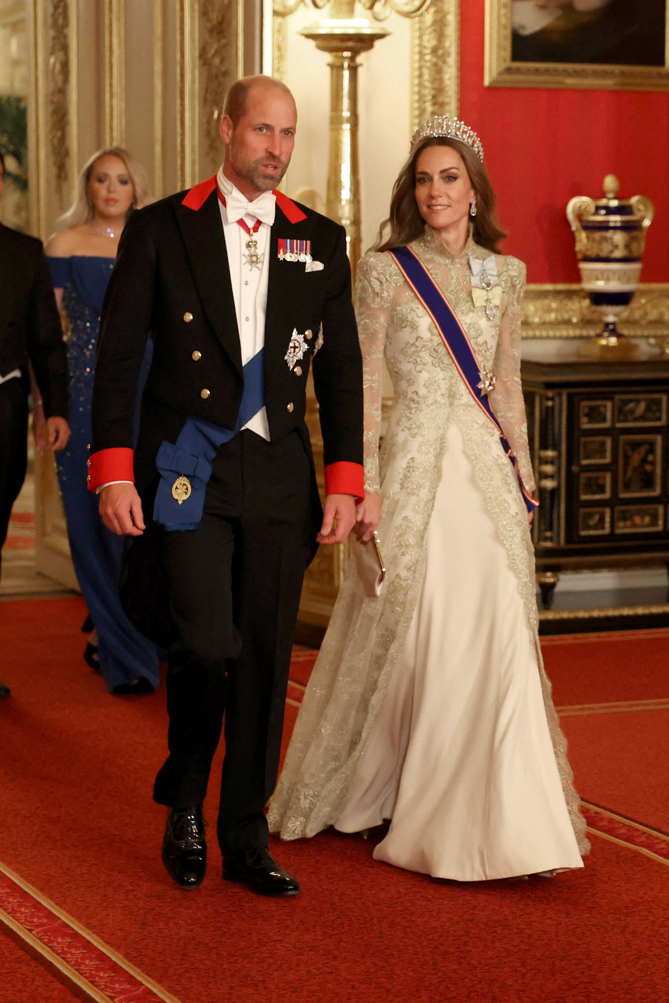 Kate Middleton wearing a gold gown walking with Prince William at a banquet