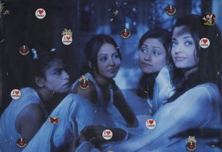 A photograph of four young women sitting in white clothes in a room has a blue-shaded hue and is covered in clips that read "I Love London"