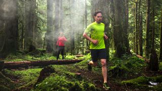 Two people trail running in the woods