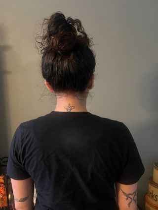 photo from the back of Gabrielle Ulubay wearing a tall topknot in her hair
