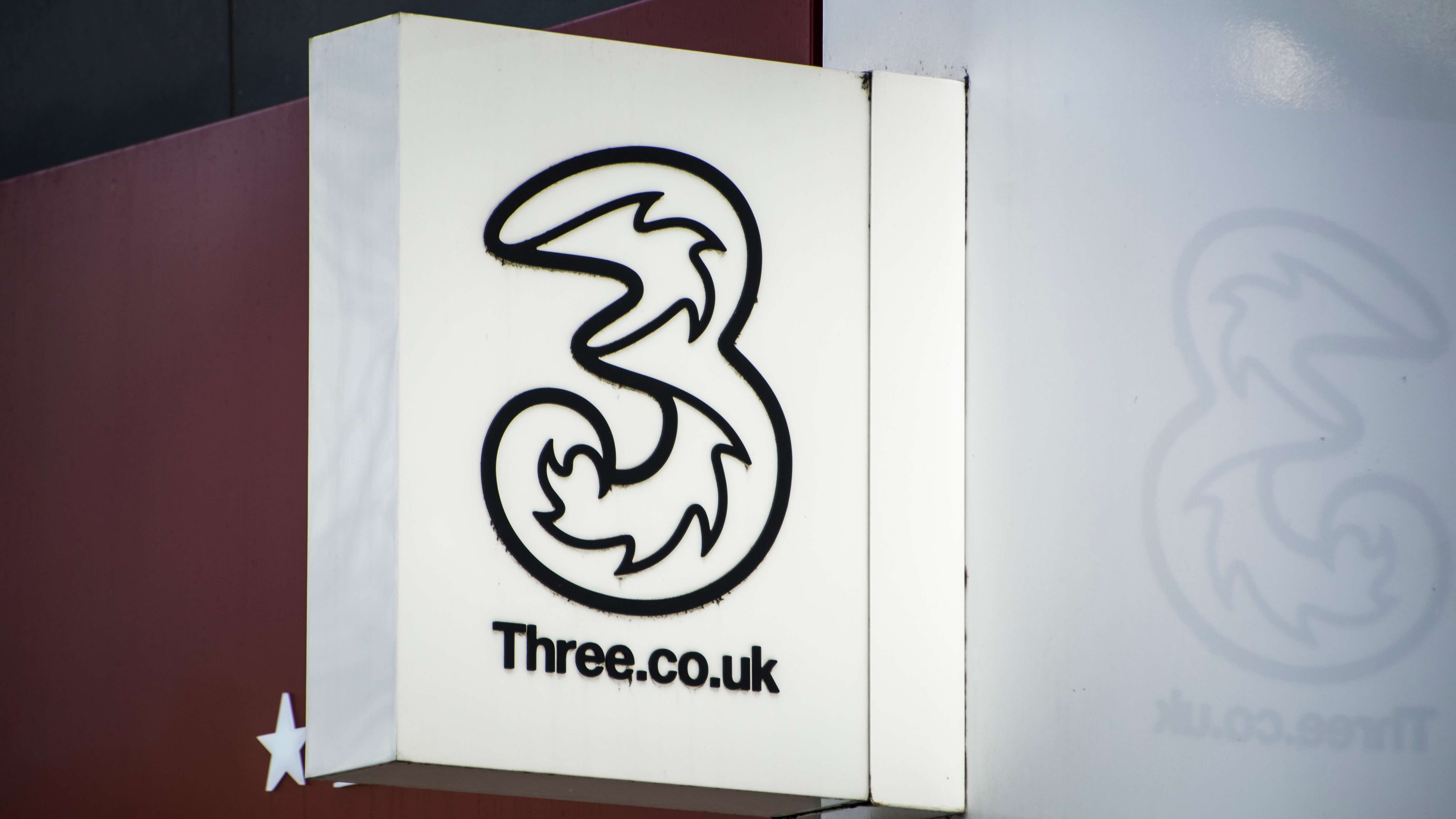 A photo of a Three UK sign outside a store
