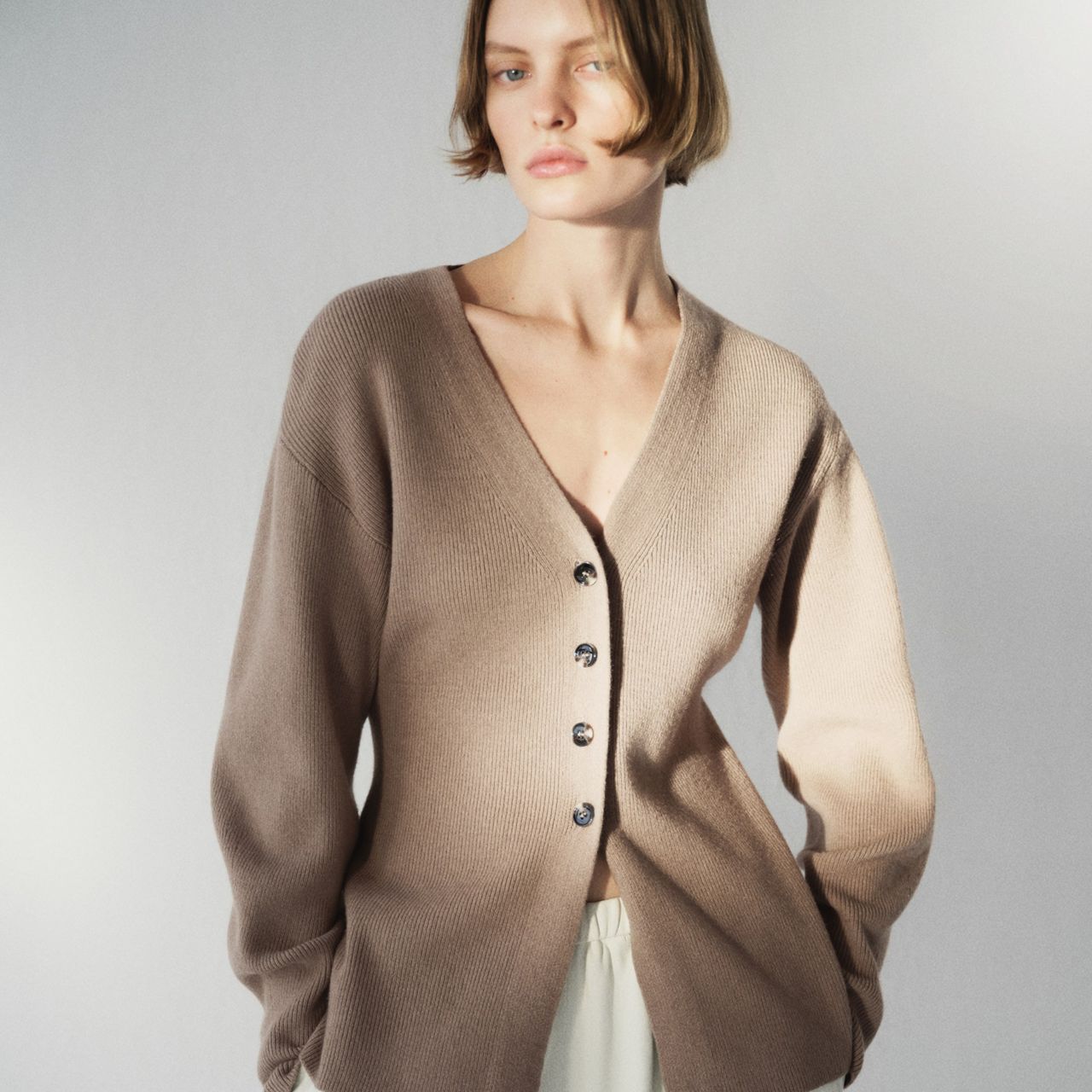 A model wearing a waisted cardigan from H&amp;M.