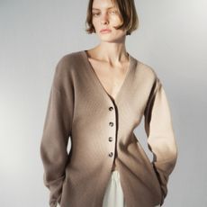 A model wearing a waisted cardigan from H&M.