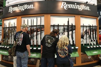 People look at a Remington gun display.
