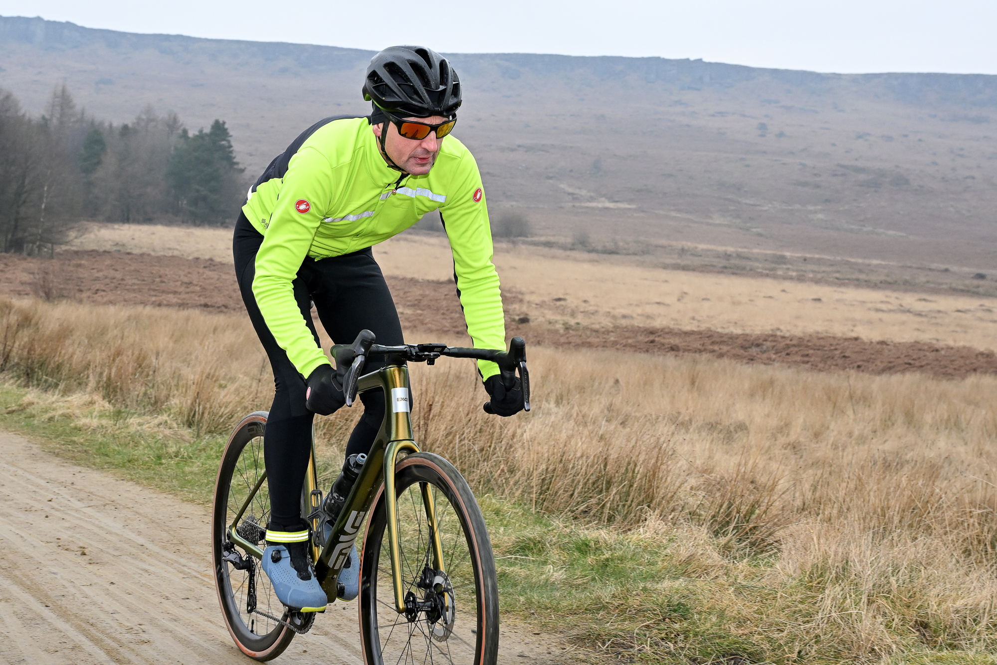 Man riding a road bike on a sandy trail
