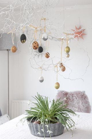 dining room with easter tree branches hanging down with easter egg decorations