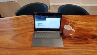 Hopeinen Surface Laptop 5 puisella pöydällä kahvikupin vieressä