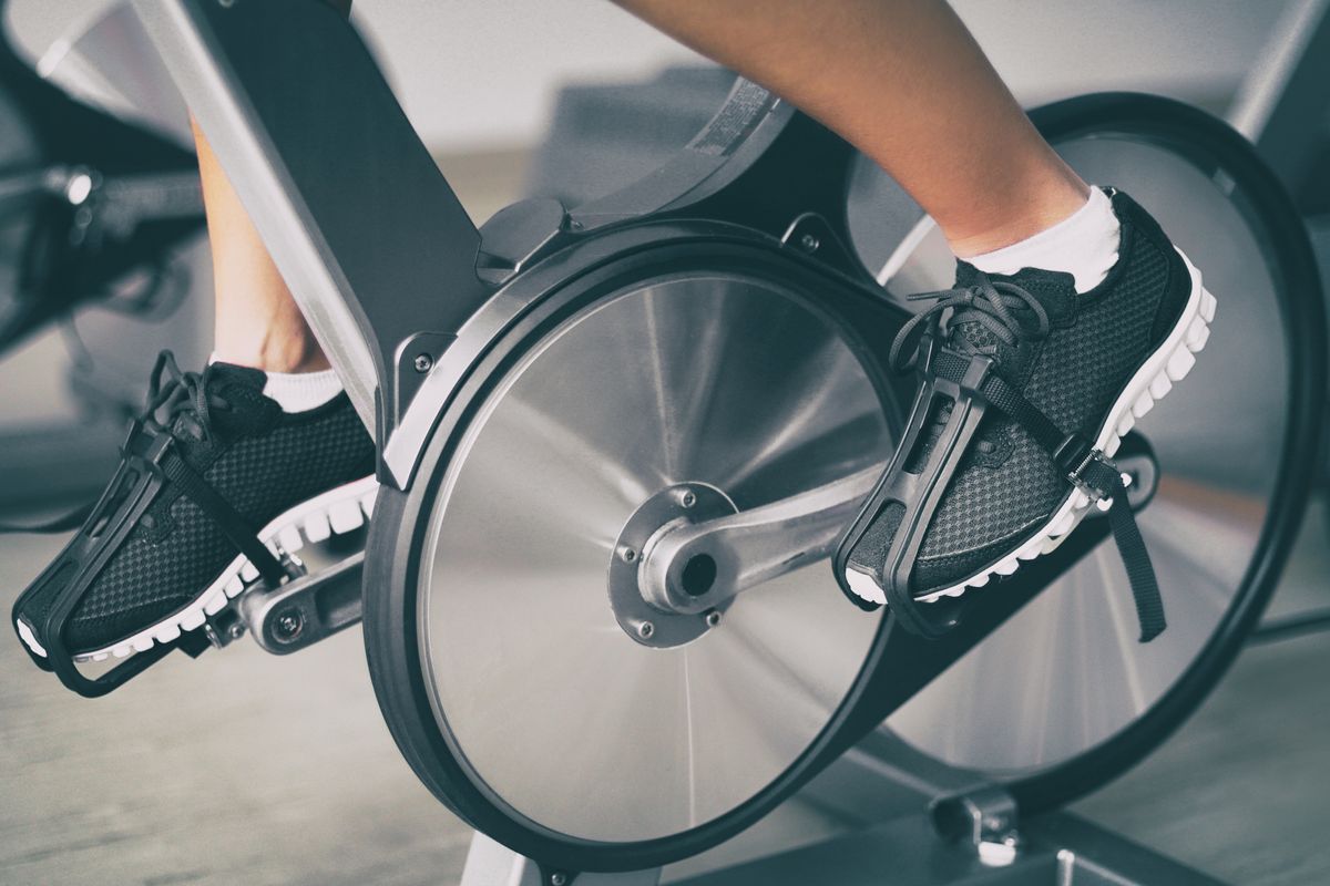 Peloton bike&amp;#039;s wheels with a person&amp;#039;s feet on the pedals