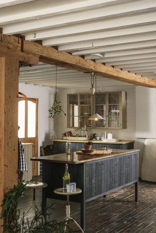 wooden freestanding kitchen with beams, wall cabinet, wooden floor, vintage metal bar stools, rise and fall pendant, sprig of mistletoe