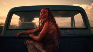 Marilyn Burns laughing at back of pickup covered in blood at the end of The Texas Chainsaw Massacre