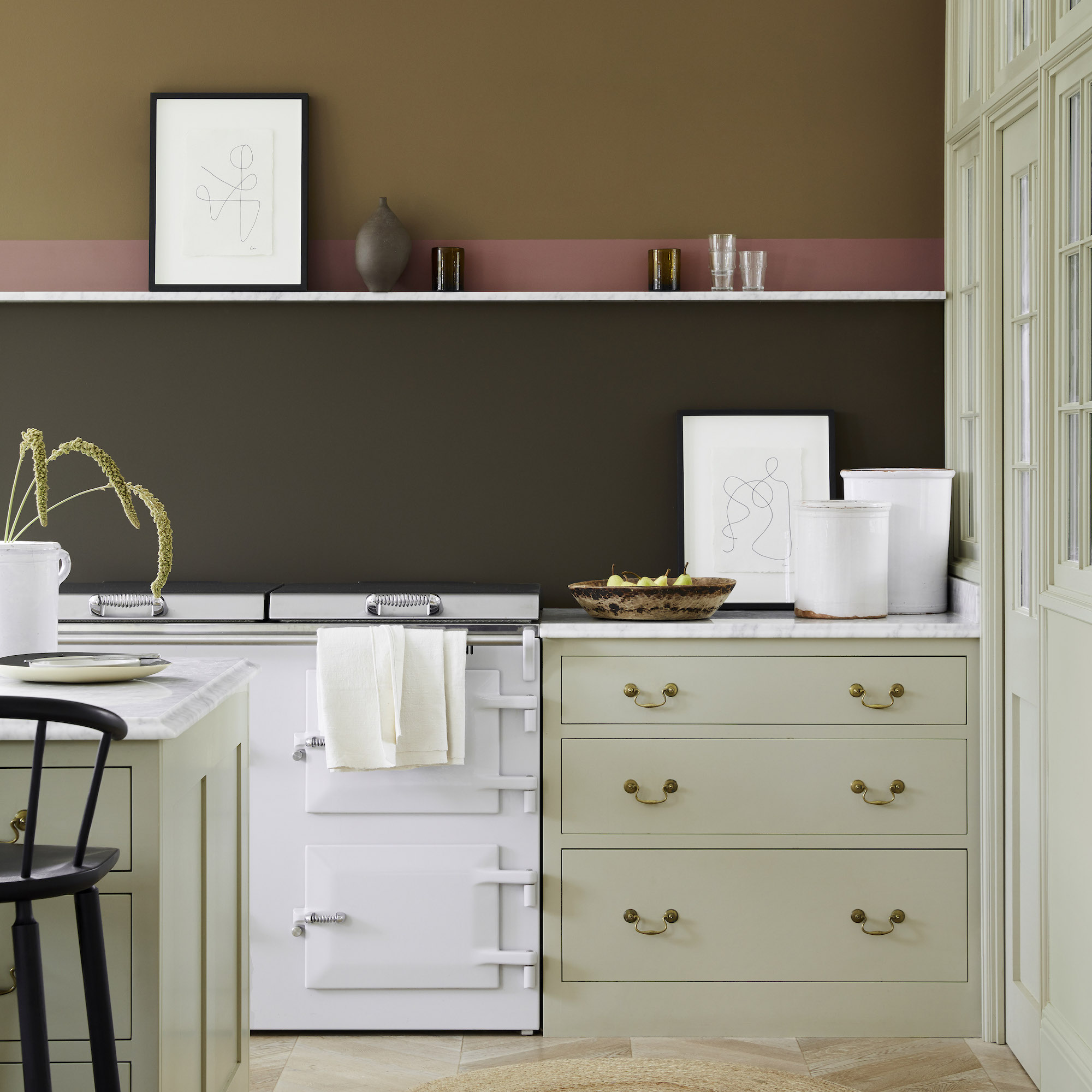 moss green kitchen with a single white shelf on brown and pink walls