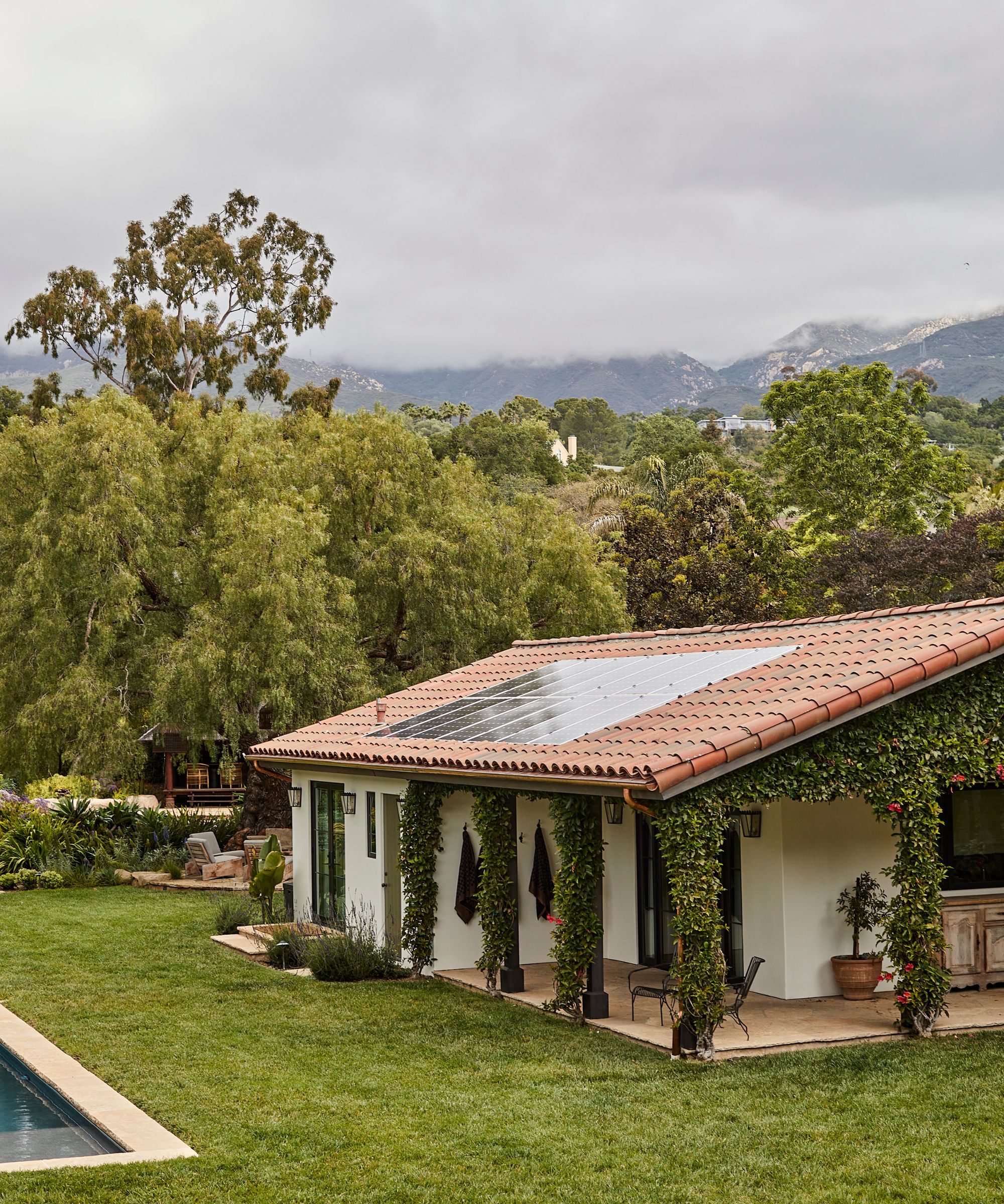 a spanish style casita guest house sat by a pool in lush gardens