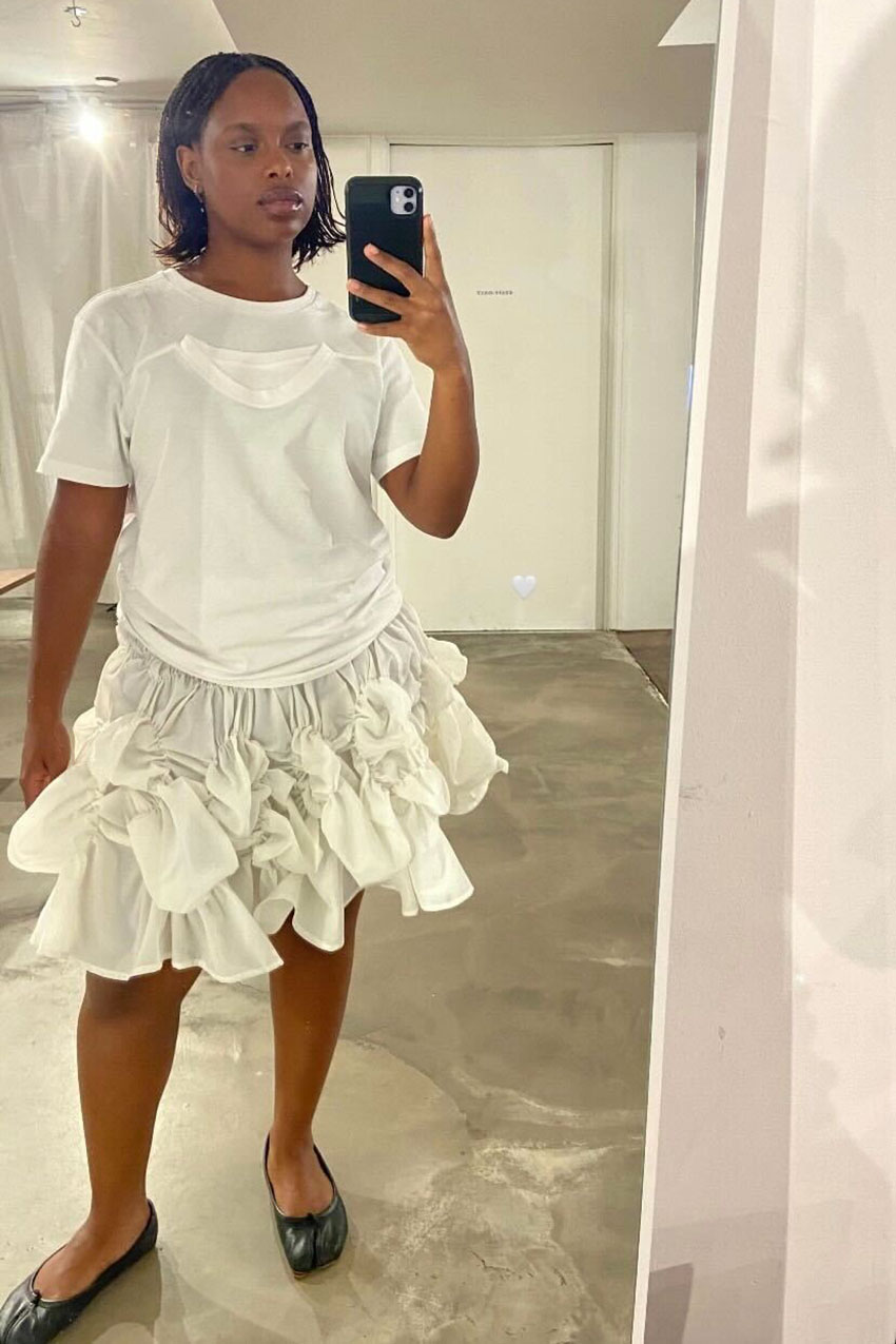 A woman in a white t-shirt and skirt