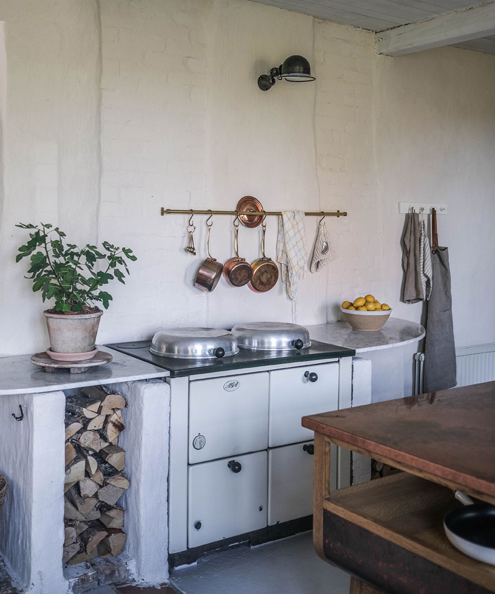 rustic kitchen with white exposed brick wall, white units and rail and hook