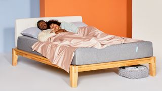 A couple sleeps on the Siena Memory Foam Mattress in an orange bedroom
