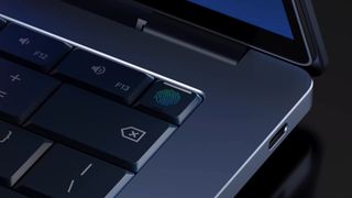 A screenshot from the promotional launch video of Google's Googlebook, showing a close-up view of the corner of the laptop and its power button, with a built-in fingerprint reader