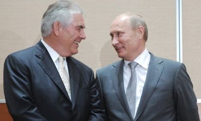 Exxon CEO Rex Tillerson (left) speaks with Russian Prime Minister Vladimir Putin (right) during the signing ceremony for a deal that gives the energy giant access to oil in the Russian Arctic