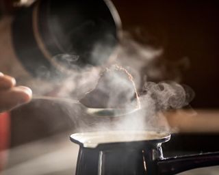 Close-up of a Man Preparing Coffee in Coffee Pot on Stove