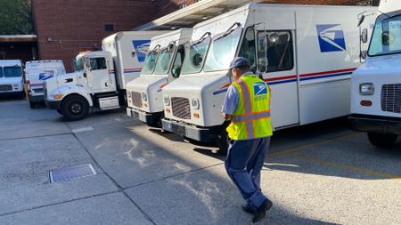 A postal worker walks to his truck in Queens, New York.