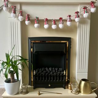 Christmas gonk garland hanging on fireplace