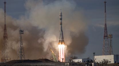 A Soyuz rocket taking off from a launch pad in daylight hours