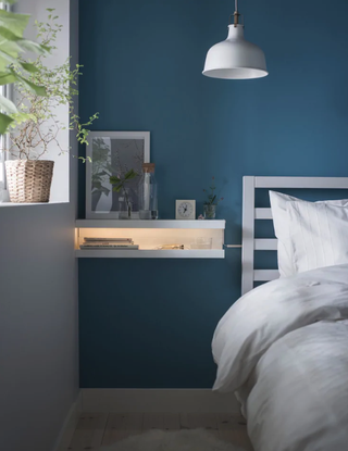 A blue and grey bedroom by ikea with picture ledge