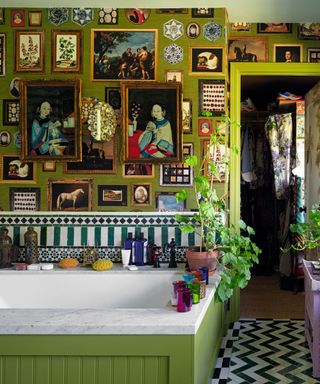 maximalist bathroom with green walls and loads of artwork