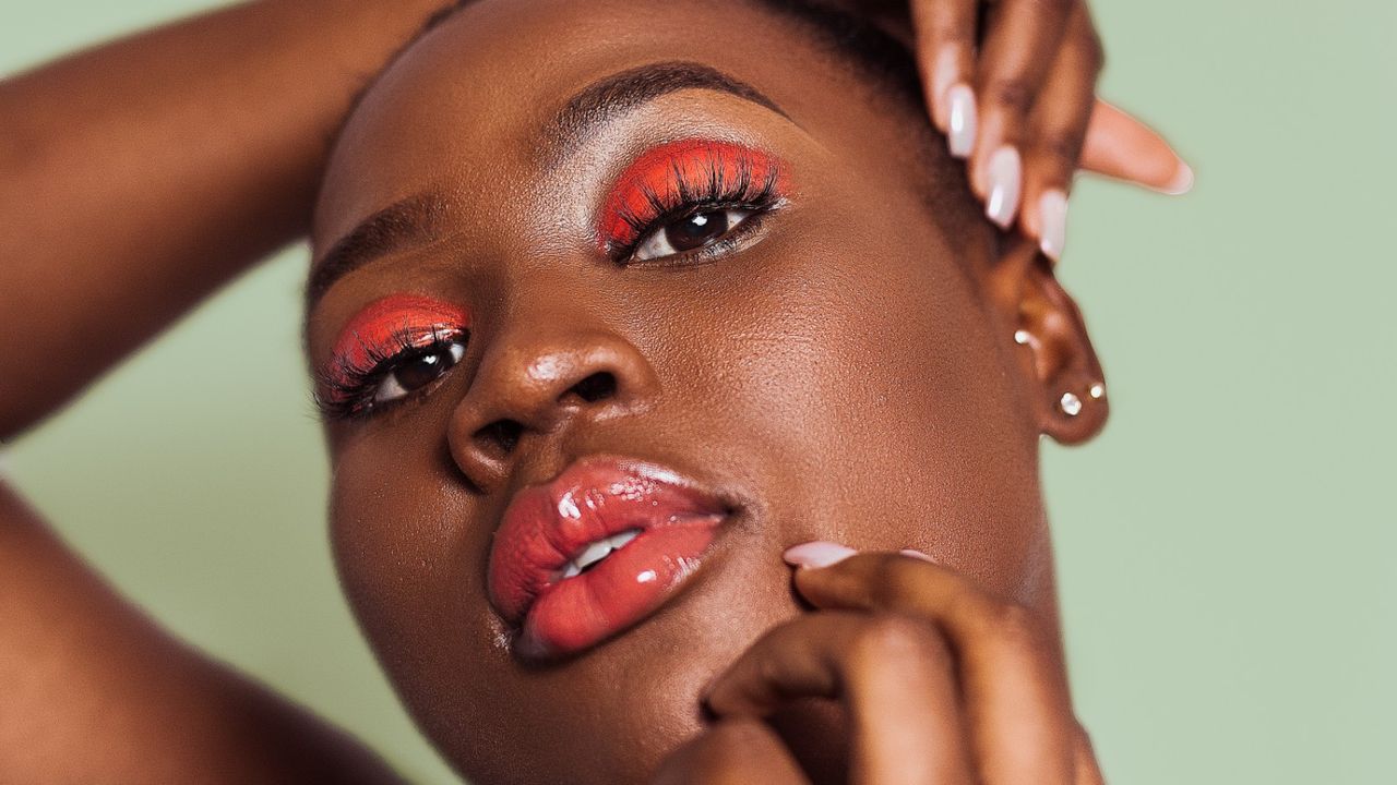 Woman wearing bright orange eye shadow and lip gloss