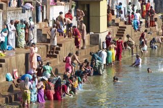 Pilgrims taking a ritual dip during Shivaratri festival in the Kotitheertha (Koti Thirtha) tank, a man made temple tank or lake used for immersion of idols and ritual bathing.