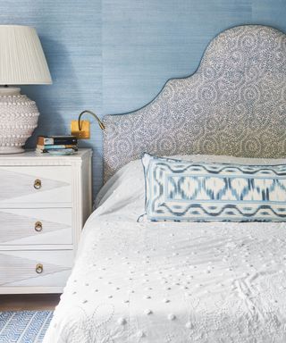 bedroom with textured blue walls and patterned headboard