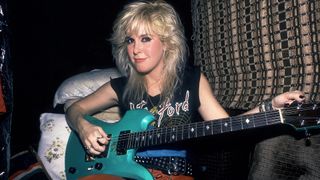 Portrait of American Rock musician Lita Ford as she poses with a guitar in her tour bus, Chicago, Illinois, September 30, 1984.