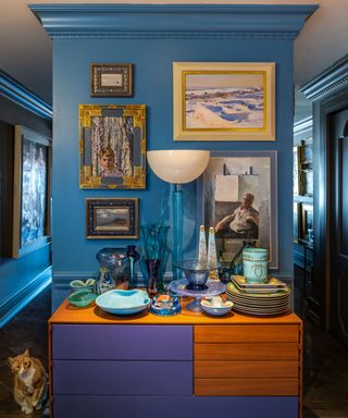 kitchen with blue walls and gallery wall of paintings