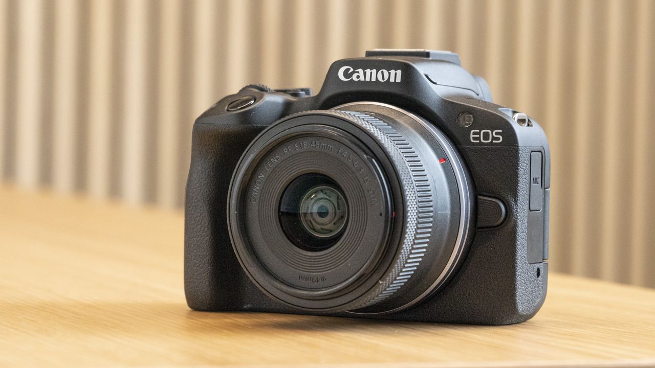 Canon EOS R50 on a table angled front with RF-S 18-45mm lens attached