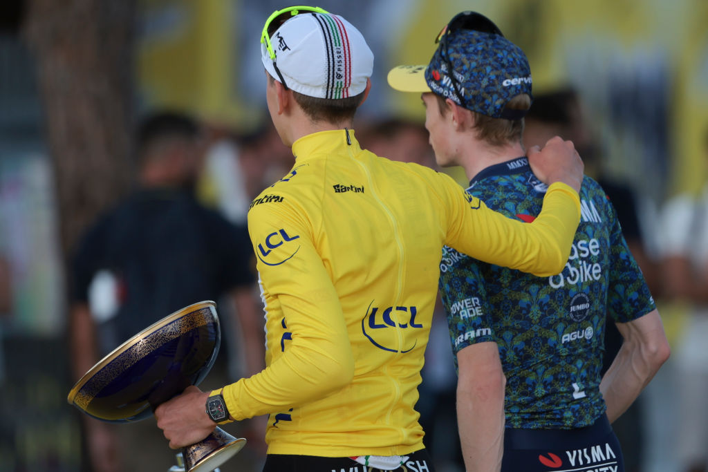 Tadej Pogacar walks away from the 2024 Tour de France podium with his arm around Jonas Vingegaard