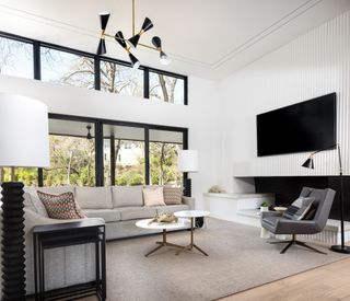 This ultra modern living room with its monochromatic scheme has a slightly elevated ceiling that gives it a contemporary edge. The use of white on the walls together with the ceiling helps to bounce the light around. Adding a neutral shade like taupe softens the overall look.