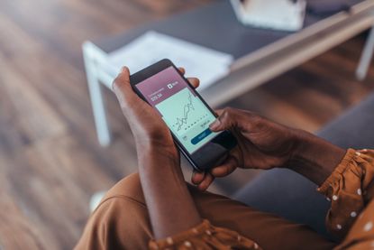 a person looking at investing on their mobile phone