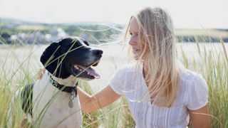 Woman stroking her dog outside
