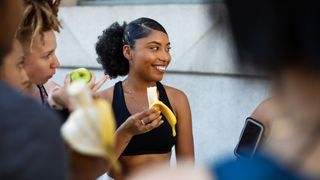 Woman in gym kit eating banana