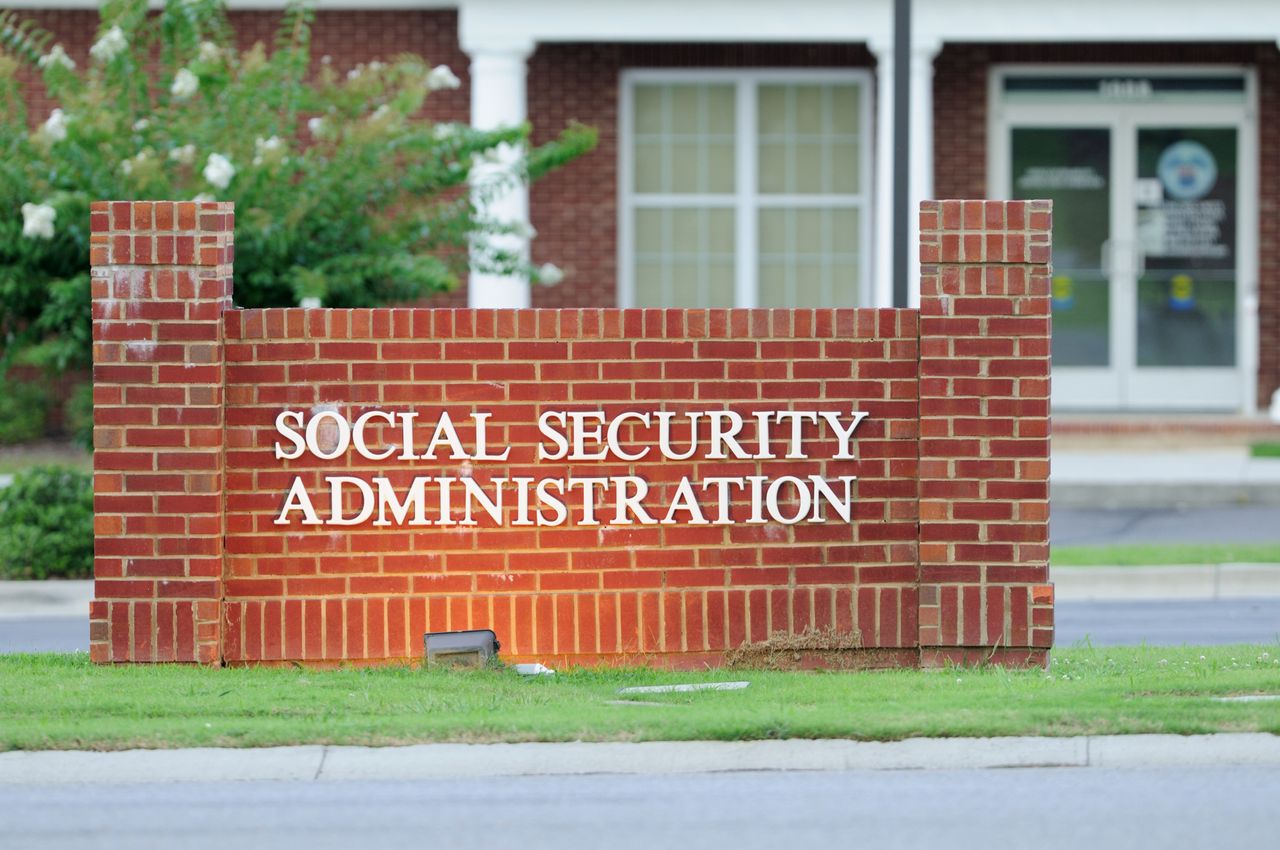 Illuminated social security administration sign in front of building.