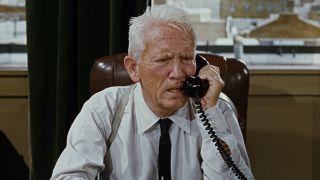 Captain T. G. Culpeper (Spencer Tracy) takes a call in It's A Mad, Mad, Mad, Mad World