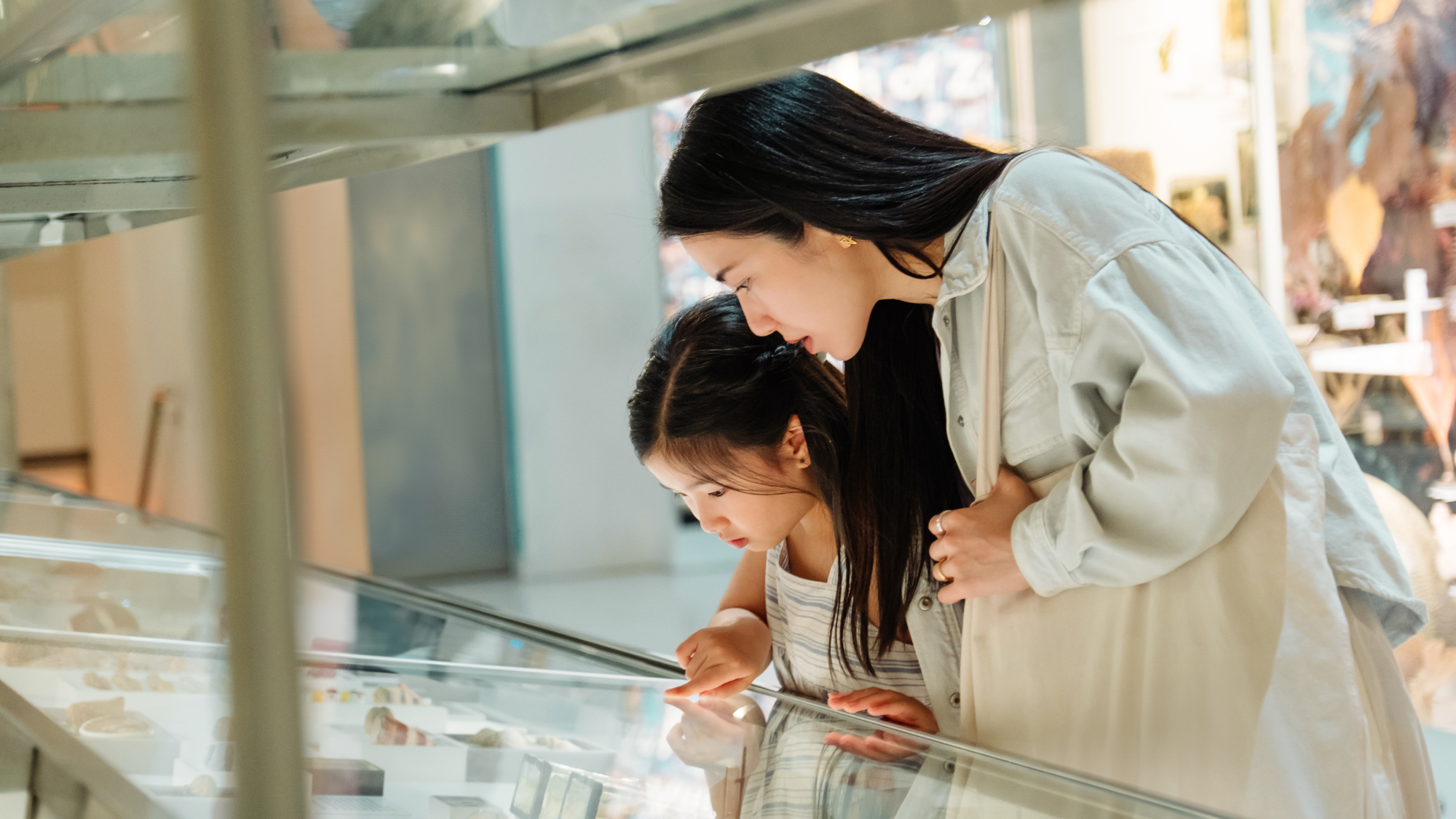 Mother and daughter looking at exhibits in a museum