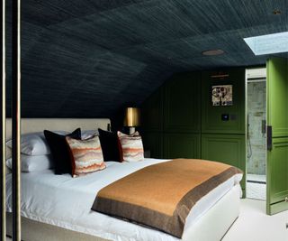 Dark attic bedroom with a hidden door to an ensuite, interior by Erik Munro